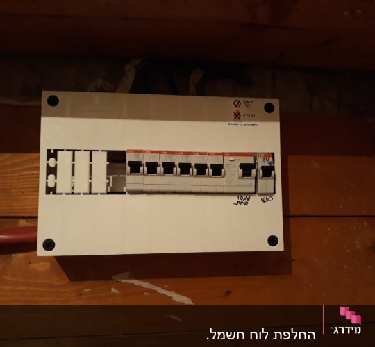 לוח חשמל עם מפסקים על קיר עץ